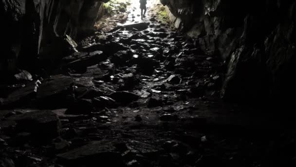 O viajante desce à caverna. Imagens de stock. Viajante explora túnel caverna descendo corda. Túneis de caverna perigosos, escorregadios da umidade e inspiram o medo da escuridão desconhecida — Vídeo de Stock