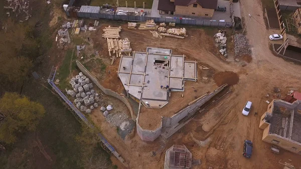 Yeni modern yazlık, inşaat malzemeleri ve inşaat malzemeleri vakıf için beton dökme yakın devam eden şantiye havadan görünümü. Klip. Yeni bina yapım süreci.