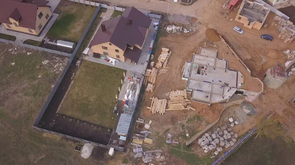 Yeni modern yazlık, inşaat malzemeleri ve inşaat malzemeleri vakıf için beton dökme yakın devam eden şantiye havadan görünümü. Klip. Yeni bina yapım süreci.