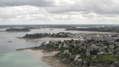 Gri bulutlu gökyüzüne karşı yaz aylarında nehir yakınında gri eski Avrupa kenti ve parlak yeşil bitki örtüsü kontrast havadan görünümü. Eylem. Güzel Avrupa mimarisi