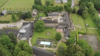 Avrupa gri yazlık evlerin havadan görünümü ve bulutlu yaz gününde yeşil ağaçlarla çevrili yüzme havuzu ile arsa. Eylem. Güzel kırsal görünümleri