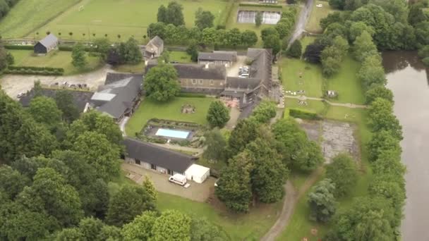 Aerial view of European grey summer houses and plot with swimming pool surrounded by green trees in cloudy summer day. Action. Beautiful countryside views — Stock Video