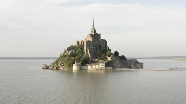 Luchtfoto van de beroemde Franse bezienswaardigheid Mont-Saint-Michel gelegen op het kleine eiland in de buurt van de rivier. Actie. Prachtig uitzicht op de oude gotische architectuur — Stockvideo