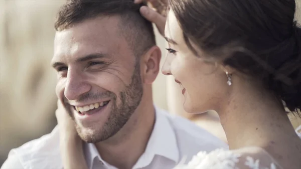 Nahaufnahme von jungen und schönen Brautpaaren, die sich küssen. Aktion. aufrichtiges und strahlendes Lächeln von Braut und Bräutigam im Sonnenlicht. Konzept der Liebe — Stockfoto