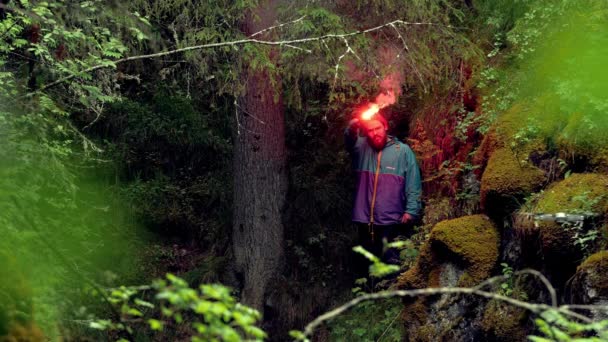 흡연 빨간색 신호 화재. 스톡 푸티지. 여행자는 갇혀 숲에서 잃어버린 구조에 대한 붉은 화재 신호를 점화. 숲에서 하이킹하는 동안 길을 잃은, 사람이 신호 플레어를 켜고 찾을 수 있도록 손을 흔들어 — 비디오