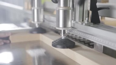 Marangoz matkaplar ile endüstriyel makine üzerinde çalışıyor. Eylem. Ahşap tahta delikler yapan endüstriyel makine üzerine sabitlenir. Ahşap işletmede profesyonel ekipmanlar