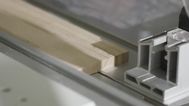Κοντινό κύκλωμα κοπής ξύλινη σανίδα σε πριόνι. Δράση. Βιομηχανική μηχανή με κυκλικό πριόνι κόβει ξύλινη σανίδα. Εργαζόμενος ξυλουργείο κατάστημα που εργάζεται στο μηχάνημα για την κοπή του ξύλου — Αρχείο Βίντεο