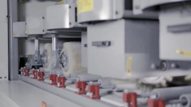 Endüstriyel üretimde fırçalar. Eylem. Temizleme ve boyama için kıllı nozullara sahip otomatik makineler. Ahşap panolarıişlemek için endüstriyel makinelerde döner fırçalar