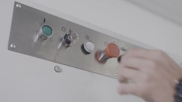 Egineer turns key on control panel. Action. Close-up of workers hand turns power key for operation of industrial equipment. Control panel with key on industrial machine — Stock Video