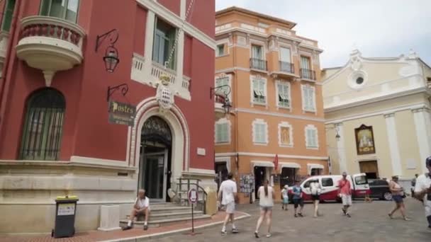 Γαλλία, Παρίσι-Ιούνιος, 2019: πόλη θέρετρο με πολύχρωμα σπίτια και περιπατητής τουρίστες. Δράση. Μικρή πλατεία πόλης με πολύχρωμα σπίτια σε ευρωπαϊκό στιλ και τους τουρίστες πεζοπορίας την καλοκαιρινή μέρα — Αρχείο Βίντεο