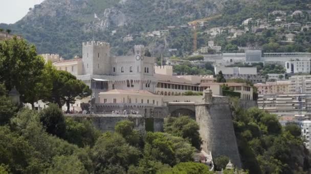 Little castle on background of town. Action. Old architecture of castle with chapel. Small castle is located near resort mountain town. Old architecture on background of modern city — Stock Video