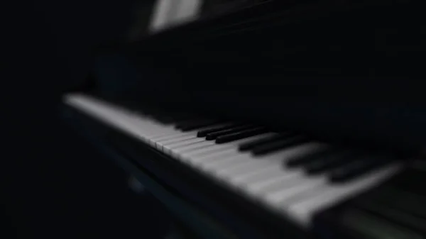 Animáció a luxus fekete zongora fehér homályos billentyűk a sötétben. Animáció. 3D render illusztráció. 4k animáció. — Stock Fotó