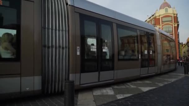 Francia, Parigi - giugno 2019: tram moderni che viaggiano lungo le rotaie. Azione. Moderni modelli eleganti di tram non hanno bisogno di fili. Nuovi tram su rotaie della città europea con turisti a piedi — Video Stock