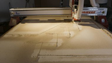 Ahşap kesme makinesi. Eylem. Otomatik makine kurumsal ahşap panoları kesme. Ahşap için şekil kesme makinesi