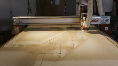 Ahşap kesme makinesi. Eylem. Otomatik makine kurumsal ahşap panoları kesme. Ahşap için şekil kesme makinesi