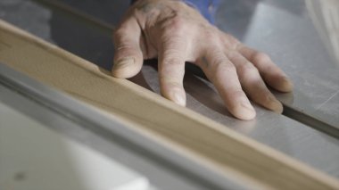 Testere makinesinde ahşap tahta kesme yakın çekim. Eylem. Dairesel testere ile endüstriyel makine kesikler ahşap tahta. Ahşap kesme makinesinde çalışan işçi ahşap atölyesi