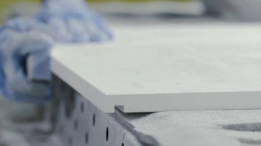 Yakın çekim işçi el parlatma ahşap tahta. Eylem. Eldivenli işçi, zımpara tahtası tahta sını parlatmak. Whetstone yaygın ahşap yüzeylerin manuel taşlama için kullanılır