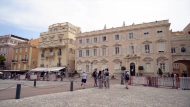 Fransa, Paris -Haziran 2019: Renkli evleri ve yürüyen turistleri ile tatil beldesi. Eylem. Avrupa tarzında renkli evler ve yaz gününde yürüyen turistler ile küçük kasaba meydanı