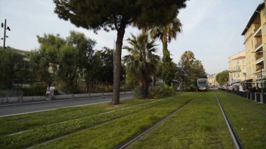 Fransa, Paris - Haziran, 2019: Modern tramvaylar raylar boyunca sürme. Eylem. Modern ve şık tramvay modelleri için tel gerekmez. Avrupa'nın raylarında yürüyen turistlerle yeni tramvaylar geziliyor