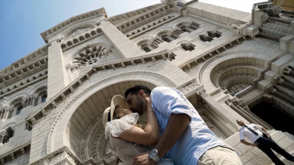 在大教堂的背景中亲吻情侣。行动。可爱的年轻夫妇在欧洲美丽的大教堂接吻。在欧洲度蜜月的新婚夫妇 — 图库照片