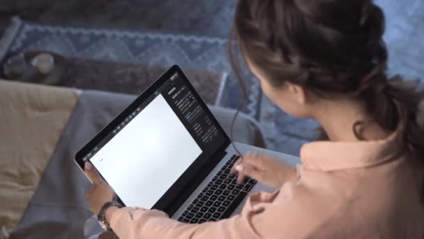 Vista superior de mujeres jóvenes en camisa rosa trabajando en su computadora portátil y escribiendo texto en algún programa con pantalla de espacio en blanco. Imágenes de archivo. Hermosa mujer joven que trabaja en casa — Vídeo de stock