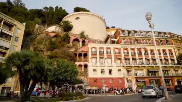 Frankrijk, Nice-juni, 2019: mooi toeristisch hotel in Europese stijl. Actie. Groot hotel met prachtige gevel en Walking toeristen op trappen in rots. Zomer vakantie in Europa — Stockvideo