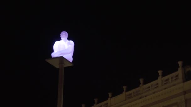 Design verlichting op straat. Actie. Lantaarn in de vorm van man zittende man op achtergrond van donkere nachtelijke hemel. Ongewone oplossing voor het verlichten van straten in de stad met lantaarns in de vorm van persoon — Stockvideo