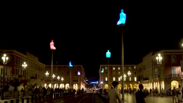 Night town square with walking tourists. Action. Beautiful lights illuminating city alley with walking tourists in summer night. City square with european style houses is filled with people — Stock Video