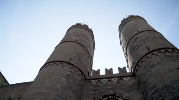Bottom view of old fortress towers. Action. Two towers of old castle rise on background of blue sky. Beautiful and powerful view of ancient construction of fortress towers — Stock Video