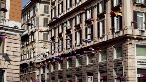 La calle de la ciudad está cubierta de decoraciones coloridas. Acción. Calle con edificios arquitectónicos antiguos está decorado con decoraciones de colores — Vídeos de Stock