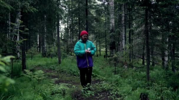 Hombre con bombas de humo de colores en la naturaleza. Imágenes de archivo. Un joven prendió fuego a las bombas de humo y brillaron antes de fumar en el bosque. — Vídeo de stock