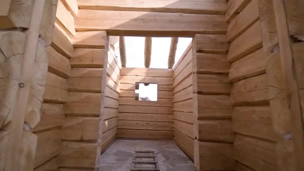 Всередині дерев'яного будинку, що будується. Кліп. Коридорний дерев'яний будинок в процесі будівництва. Красива дерев'яна стіна в будинку, що будується — стокове відео
