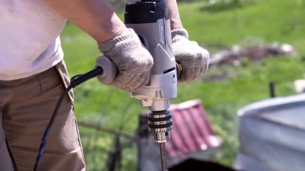 Närbild av elektriska borrar för borrning av virke. Klipp. Stor elektronisk borr för borrhål i ribbor eller tätt trä. Master håller stor borr i snickeriarbeten — Stockvideo