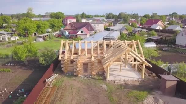 Вид сверху на строительство деревянного дома. Клип. Панорама с пригородными районами и каркасом деревянного дома в процессе строительства — стоковое видео