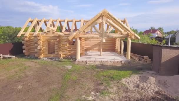 Vista superior del marco de la casa de madera en construcción. Clip. Casa de campo de madera construida de troncos se encuentra en la etapa de finalización del marco. Trabajos de construcción de cabañas privadas — Vídeo de stock