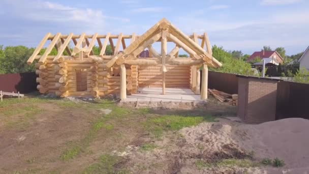 Vista superior do quadro da casa de madeira em construção. Clipe. A casa de campo de madeira de país construída de logs está na etapa da realização da armação. Obras de construção de casas particulares — Vídeo de Stock