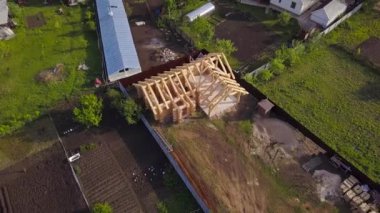 Ahşap ev inşaatı ile ilgili arsa. Şarjör. Yazın özel kır arazisindeki ahşap evin en üst görüntüsü. Yapım aşamasında olan ahşap evin çerçevesi