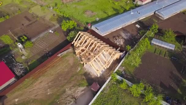 Lote com construção de casa de madeira. Clipe. Vista superior no quadro da casa de madeira na parcela de país privada no verão. Quadro de casa de madeira em processo de construção — Vídeo de Stock