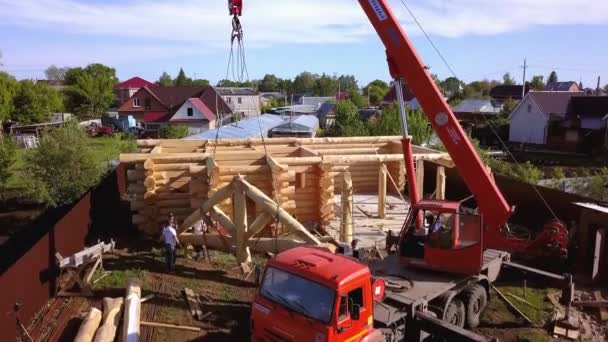 İnşaat ekibi çatı kuruyor. Şarjör. Vinç ve inşaat ekibinin bulunduğu ahşap çatının en üst görüntüsü. Ahşap ev iskeletinin inşaatı — Stok video