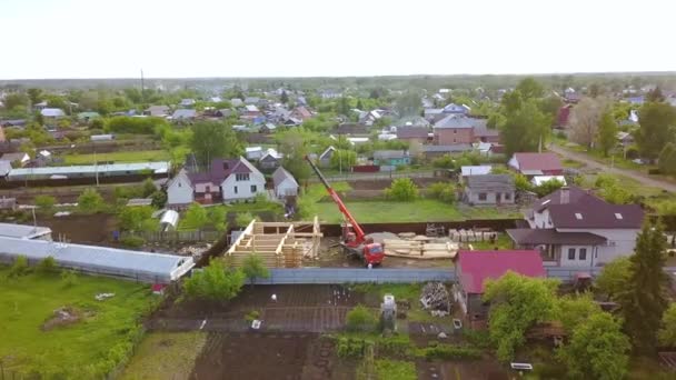 Vista superior de la construcción de casa de madera en la ciudad. Clip. Construcción de una nueva casa de madera en el pueblo rural. Casa de madera construida sobre el fondo de cabañas privadas — Vídeos de Stock