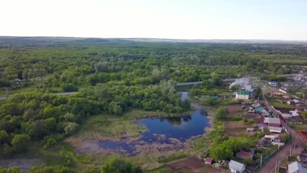 Top view of panorama of village on background of green forest. Clip. Cottage town is great place for quiet life near nature without hustle and bustle of city — Stock Footage Top view of panorama of village on background of green forest. Clip. Cottage town is great place for quiet life near nature without hustle and bustle of city Stock Footage