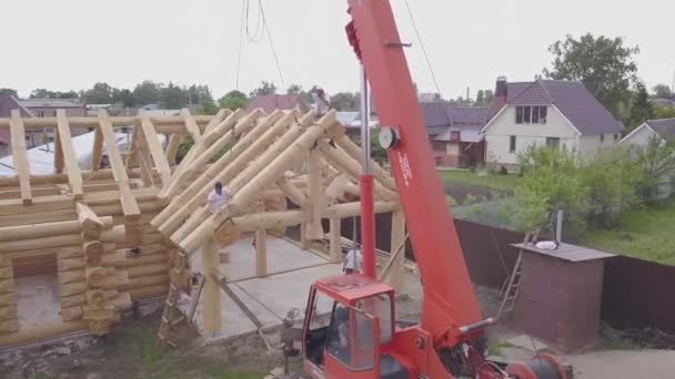 建造木制房屋的最高视图。 剪断。 以郊区小区为背景的农村木制房屋的建设过程. 与建筑商一起建造木制房屋 — 图库视频影像