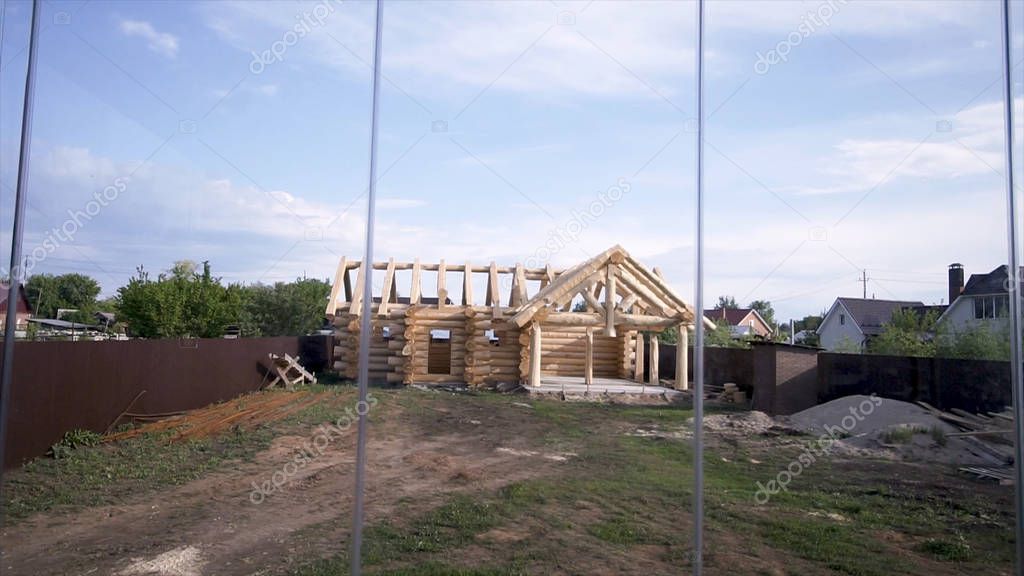 Wooden cottage in process of construction. Clip. View of wooden house without windows and roof in process of construction