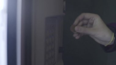 Bozuk paraları otomata sokan genç bir kadının omzundan bak. Stok görüntüleri. İçecek otomatı şişelerde su satıyor.