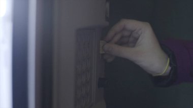 Bozuk paraları otomata sokan genç bir kadının omzundan bak. Stok görüntüleri. İçecek otomatı şişelerde su satıyor.