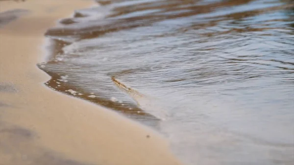 Närbild av klart havsvatten kommer nära sandstranden. Lagerbilder. Vacker semester vid havet — Stockfoto