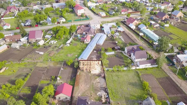 Bovenaanzicht van de bouw van houten huis in de stad. Een knip. Bouw van een nieuw houten huis op het platteland. Houten huis gebouwd op achtergrond van privé huisjes — Stockfoto