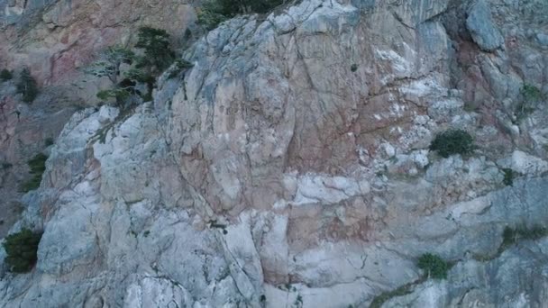 Falaise escarpée avec des rebords. Fusillade. Vue de dessus de la paroi escarpée rocheuse avec végétation clairsemée sur les rebords. L'érosion crée une surface instable et lâche du massif rocheux — Video