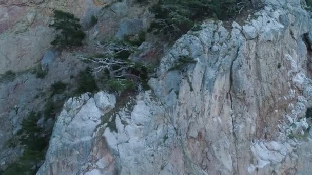 Brant klippa med avsatser. Skjuten. Ovanifrån av stenig brant vägg med gles vegetation på avsatser. Erosion skapar lös instabil yta av stenigt massiv — Stockvideo