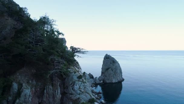 岩場の海岸と海の景色のトップビュー。撃たれた青い海と空と地平線を背景に日陰側とロッキー海岸。岩塊と海の海岸 — ストック動画